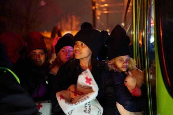 Migrants line up to sleep in a city bus parked outside Sacred Heart Church in El Paso, Texas.