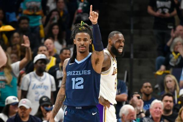 Memphis Grizzlies guard Ja Morant (12) gestures beside Los Angeles Lakers forward LeBron James (6) during Game 1 of a first-round NBA basketball playoff series Sunday, April 16, 2023, in Memphis, Tenn.