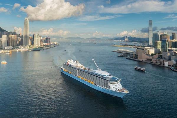Royal Caribbean Quantum of the Seas ship drives through a city port.