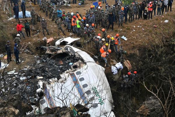 Rescuers pull the body of a victim from the Yeti Airlines plane wreckage, in Nepal's deadliest aviation disaster in 30 years.  