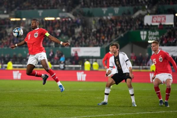Player rises to head a football towards goal.