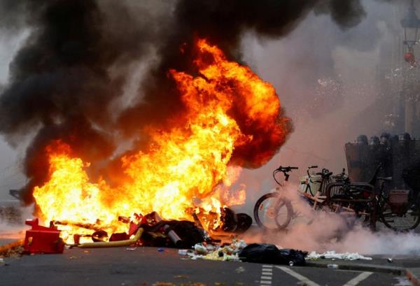 Smoke billows from a fire, as members of the Kurdish community attend a demonstration, following a shooting, in Paris, France December 24, 2022.