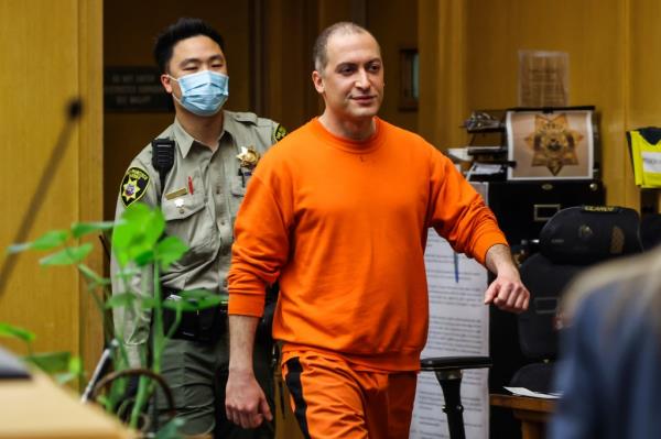 Nima Momeni, the man charged in the fatal stabbing of Cash App founder Bob Lee, smiles as he makes his way into the courtroom.