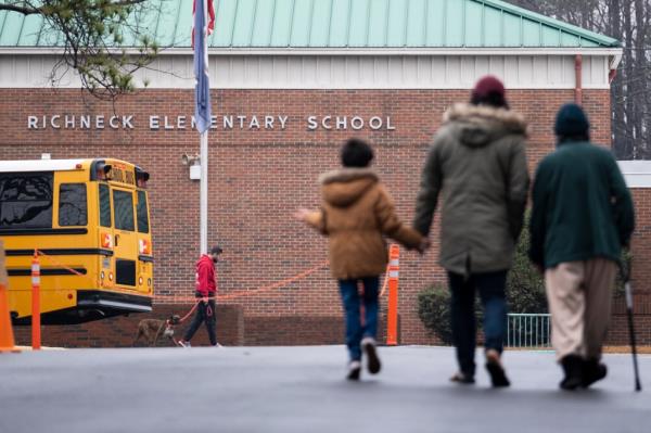 Photo of the outside of the school with a family walking in.