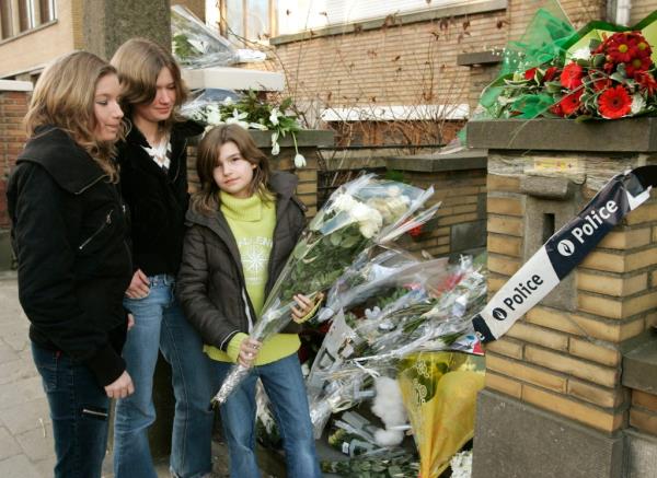 Children placing flowers in 2007 at the home wher<em></em>e the murders took place.