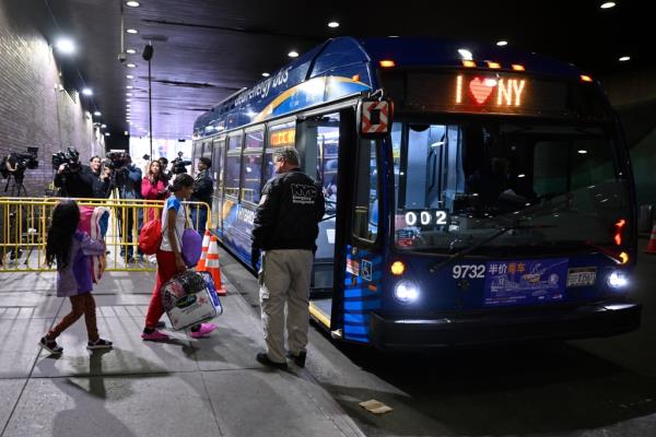 Migrants boarding another bus after arriving at the Port Authority.