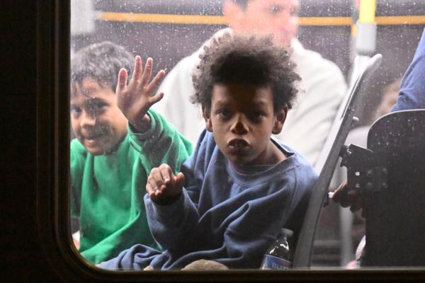 Children looking out the window after arriving in a bus from Texas.