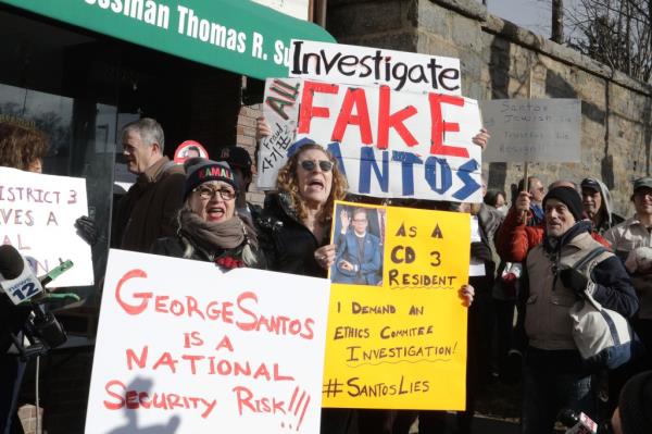Protestors with signs against Co<em></em>ngressman George Santos in front of Santo's office in Queens, NY.