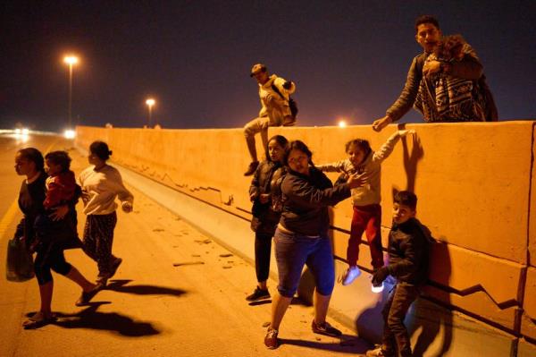 Migrants crossing the Cesar E. Chavez Border Highway after crossing the border near El Paso on January 1, 2023.