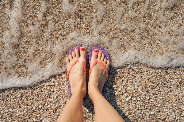 Female,Legs,Wearing,Flip,Flops,Near,Sea.,Top,View