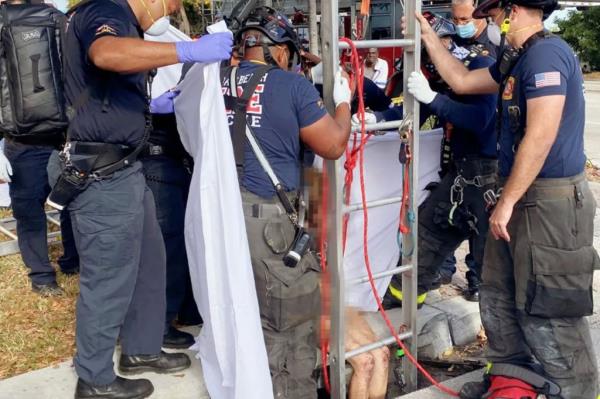 o<em></em>nly a pair of scuffed, bloody knees can be seen on Lyndsey Kennedy, 43, before she’s loaded o<em></em>nto a stretcher en route to a Florida hospital for medical treatment.