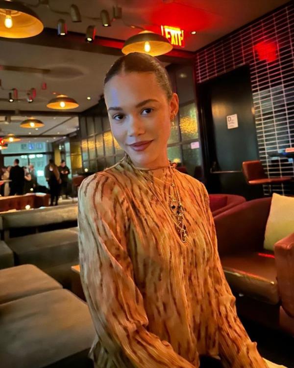 Woman wearing yellow and orange long sleeved dress.