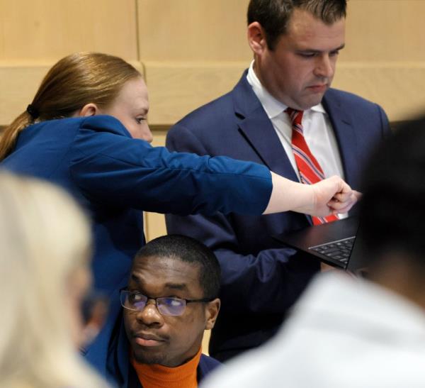 Attorneys Skyler Hill, left, and Joseph Kimok co<em></em>nfer as shooting suspect Michael Boatwright is shown at the defense table just before opening statements.