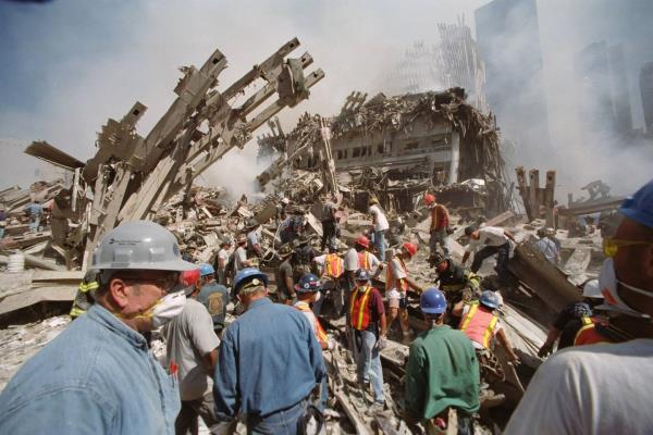 Emergency crews work amid the still-smoldering rubble as the search for survivors co<em></em>ntinues on the day after terrorists crashed two hijacked airliners into both towers of the World Trade Center.