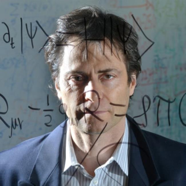 Max Tegmark stands behind a clear board with the Schr?dinger equation for quantum mechanics and Einstein's general theory of relativity written on it.