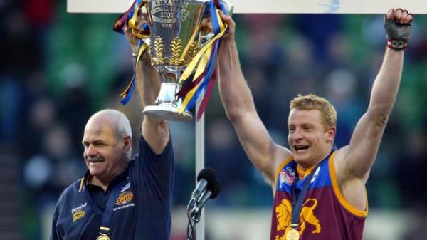 Coach Leigh Matthews holding AFL premiership cup trophy with footballer Michael Voss.</p>

<p>　　AFL football - Brisbane Lions vs Collingwood Grand Final match at MCG 27 Sep 2003. /Football/AFL